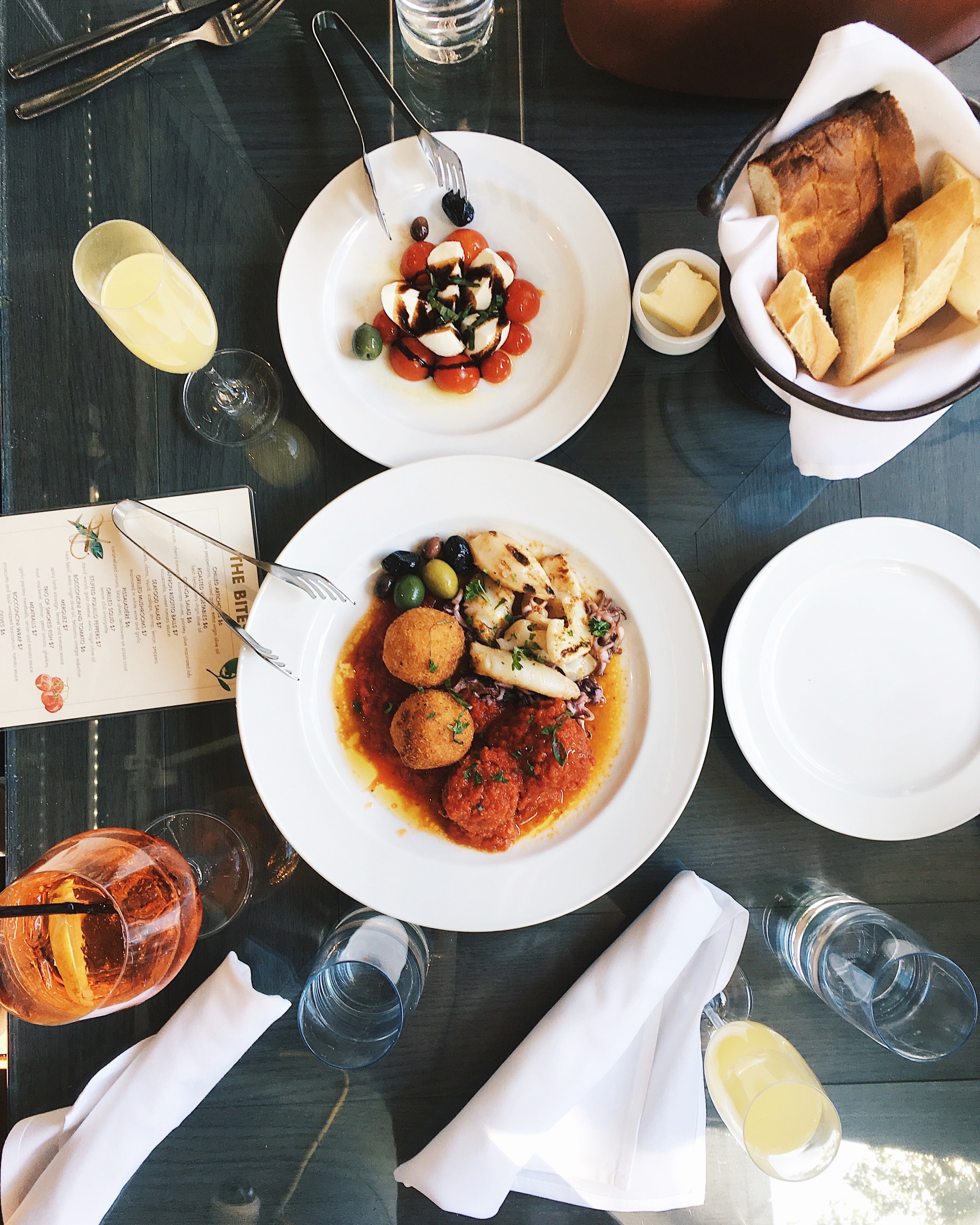 Antipasto dish of rice balls, meatballs, potatoes pictured from above.