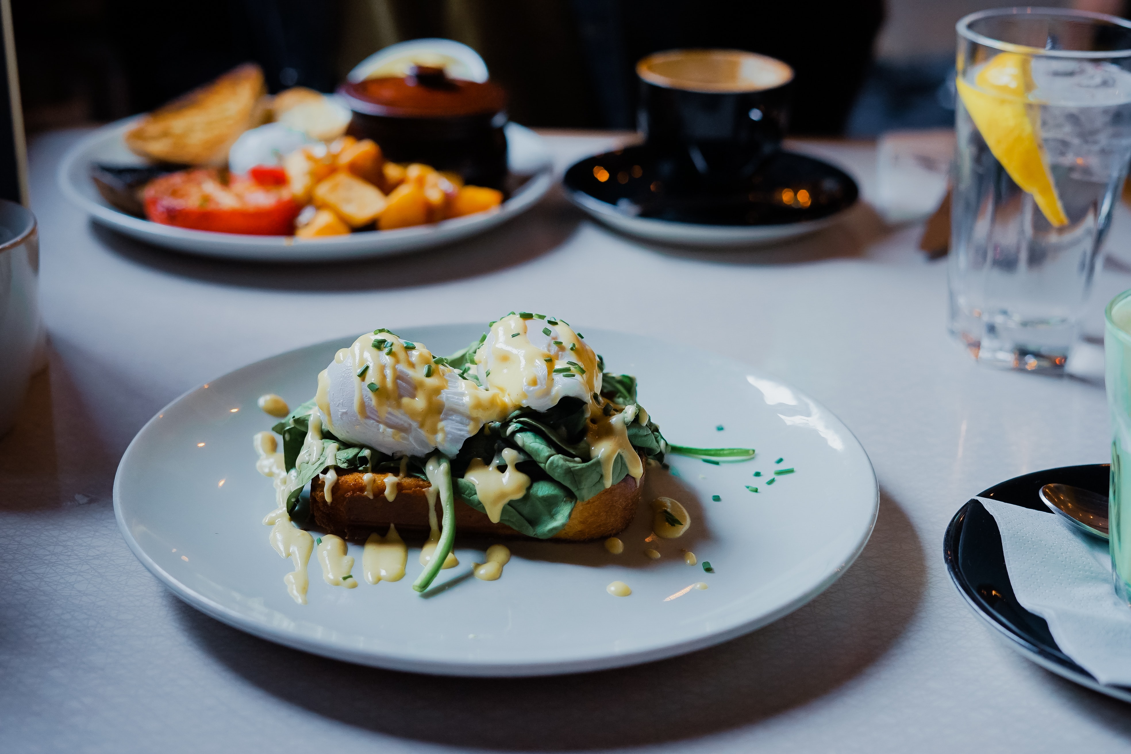 Two poached eggs over baby spinach with hollandaise sauce, on brioche toast.